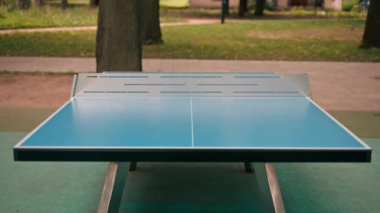Net şehir parkı açık masa tenisi spor ve eğlence konsepti olan mavi tenis masası.