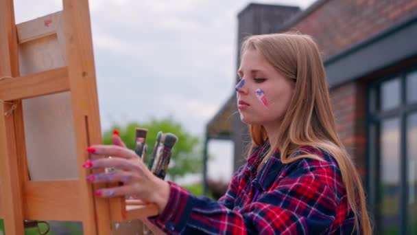 Konzentrierte Künstlerin Mit Farbe Gesicht Bemalt Ein Bild Das Mit — Stockvideo