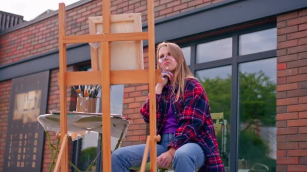 Yüzünde Boya Olan Odaklanmış Bir Kız Ressam Boya Fırçasıyla Sehpada — Stok video