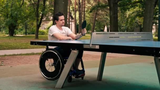 Молодой Человек Инвалидной Коляске Смотрит Теннисную Ракетку Перед Началом Игры — стоковое видео