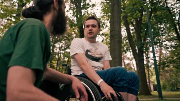 Человек Инвалидной Коляске Отдыхает Другом Который Курит Трубку Парке — стоковое видео