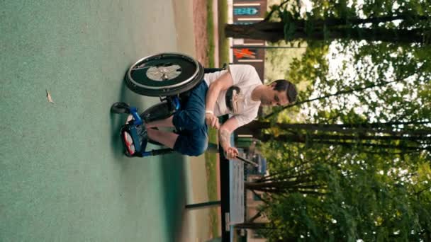 Вертикальное Видео Молодой Человек Инвалидной Коляске Смотрит Теннисную Ракетку Перед — стоковое видео