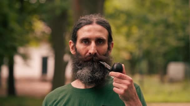 Porträtt Skäggig Vuxen Man Som Håller Pipa Med Tobak Stadsparken — Stockvideo