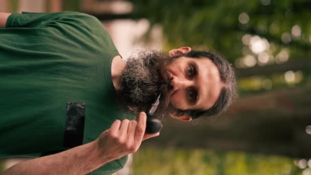 Pionowy Portret Brodatego Dorosłego Mężczyzny Trzymającego Fajkę Tytoniem Parku Miejskim — Wideo stockowe