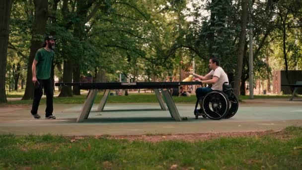 Mężczyzna Wózku Inwalidzkim Gra Ping Ponga Swoim Przyjacielem Parku Miejskim — Wideo stockowe
