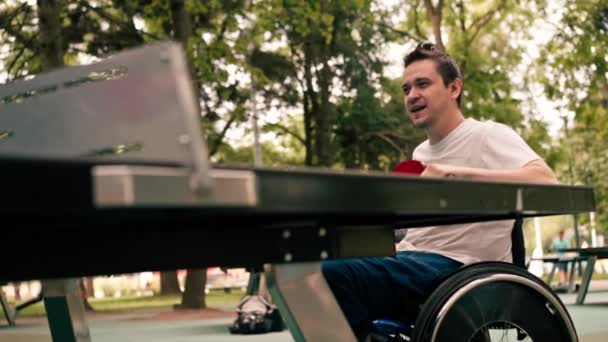 Muž Vozíčku Hraje Stolní Tenis Městském Parku Emocionálně Cvičí Své — Stock video