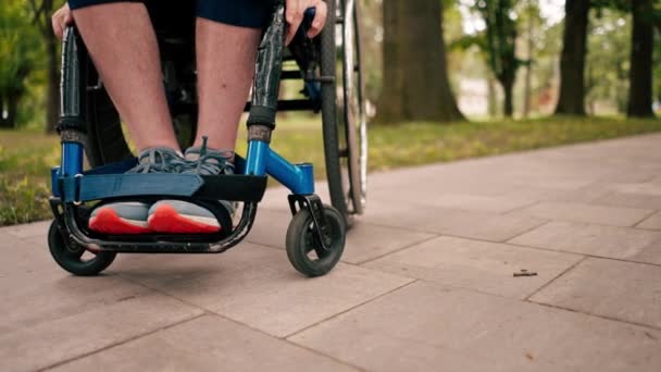 都市公園モビリティヘルスコンセプトの車椅子の男の足のクローズアップアクティブライフスタイル — ストック動画
