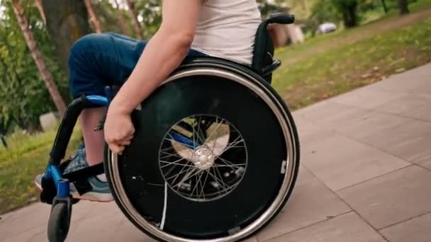 在城市公园里 一个男人坐在轮椅上表演杂技 积极地生活方式 密切地互相配合 — 图库视频影像