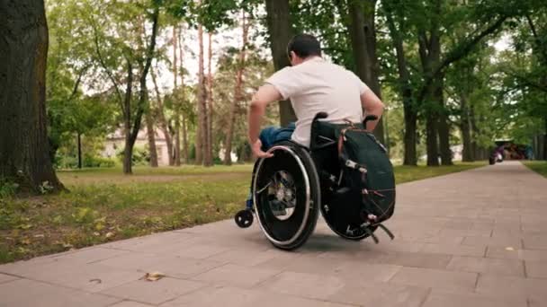 Uśmiechnięty Młody Człowiek Wykonuje Sztuczki Wózku Inwalidzkim Parku Miejskim Aktywny — Wideo stockowe