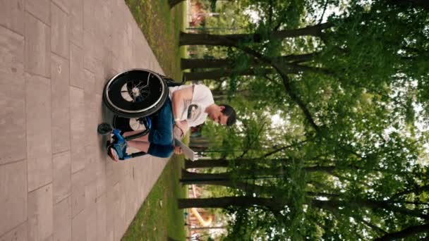 Вертикальное Видео Молодой Человек Инвалидной Коляске Пристально Смотрит Планшет Вдумчиво — стоковое видео