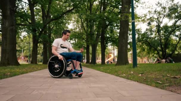 Νεαρός Άνδρας Αναπηρική Καρέκλα Κοιτάζει Προσεκτικά Τηλέφωνο Διαβάζει Συναισθηματικά Τις — Αρχείο Βίντεο