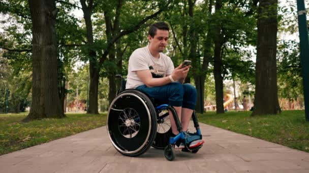 Tekerlekli Sandalyedeki Genç Adam Telefona Dikkatle Bakar Haberleri Okur Haberci — Stok video