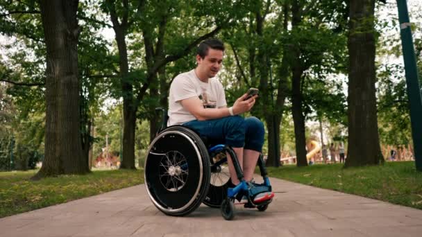 Junger Mann Rollstuhl Blickt Aufgeregt Auf Das Telefon Liest Emotional — Stockvideo