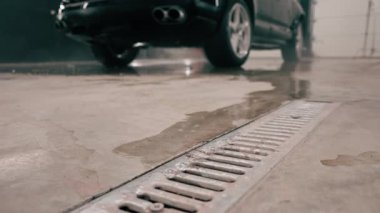 Bir oto yıkama işçisinin araba yıkama kutusundaki su ve köpüğü temizlerken çekilmiş yakın plan fotoğrafı.