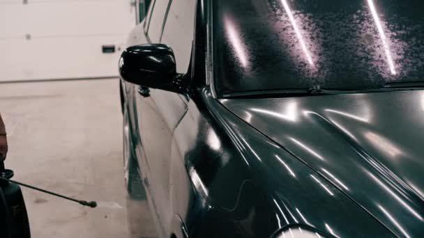 Сотрудник Автомойки Крупным Планом Применяет Автомоющее Средство Черному Роскошному Автомобилю — стоковое видео