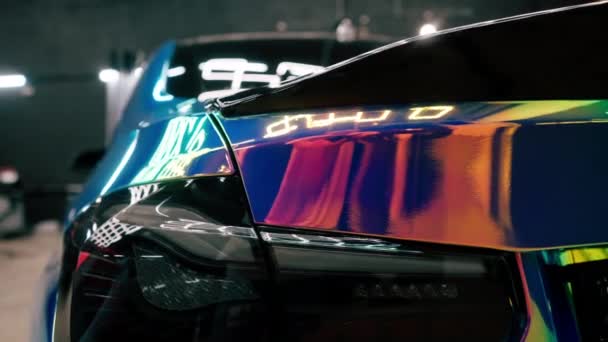 カメレオンカラー保護フィルムで覆われたラグジュアリーカーのヘッドライトとリアバンパーのクローズアップ — ストック動画