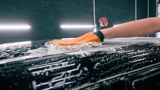 Nahaufnahme Eines Autowäschearbeiters Der Ein Mikrofasertuch Benutzt Sein Schwarzes Luxusauto — Stockvideo