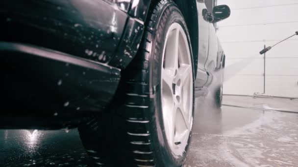 Сотрудник Автомойки Крупным Планом Применяет Автомоющее Средство Черному Роскошному Автомобилю — стоковое видео