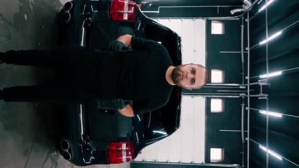 Porträt Eines Männlichen Autowäschearbeiters Der Hintergrund Eines Schwarzen Luxusautos Ein — Stockvideo