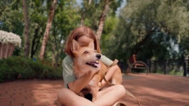 Parkta gezen küçük bir kız en sevdiği kırmızı tüylü köpeğiyle ve onun arkadaşlığı için endişeleniyor.