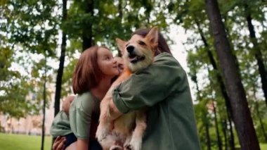 Parkta mutlu genç bir aile köpek babası kızını kucağında tutuyor güven bakımı ve aile değerleri