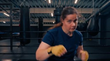 Sarı boks bandajlı kadın boksör portresi dövüşmeden önce hayali rakibini yumrukluyor.
