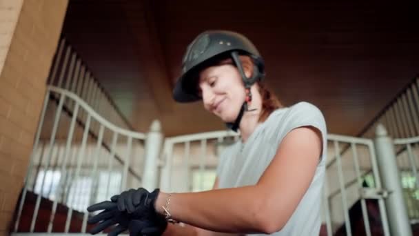 马术女子戴手套在马厩里准备骑马骑术马术女子爱情概念专业装备 — 图库视频影像