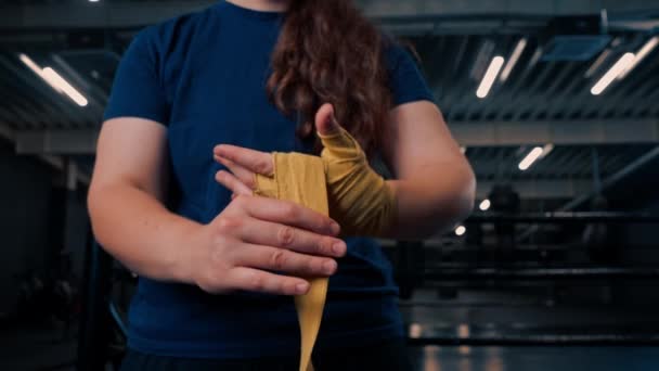 身强体壮的女孩正准备做艰苦的运动 她用绷带包裹着拳头 以保护她在体育馆里的手指 — 图库视频影像