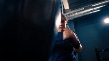 Eldivenli bir kız boksör dövüşmeden önce spor salonunda kum torbasında yumruk atmanın gücünü keşfeder.