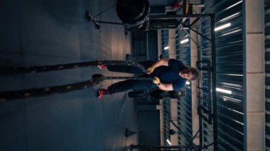 Dikey video odaklı bayan atlet spor kasları spor konseptinde halatla egzersiz yapıyor.