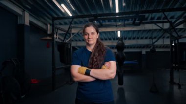 Spor antrenmanından sonra spor salonunda çalışan yorgun, ciddi kız boksör portresi.