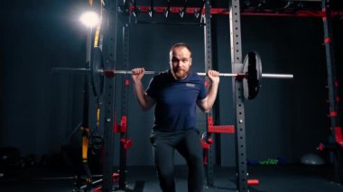 Genç motivasyonlu vücut geliştirici ağır halter spor salonunda aktif vücut bakımı yapıyor.