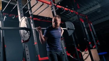 Genç motivasyonlu vücut geliştirici ağır halter spor salonunda aktif vücut bakımı yapıyor.