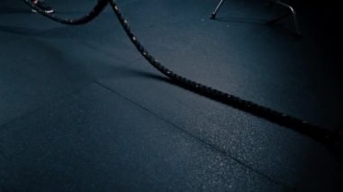 Genç erkek vücut geliştirici spor salonunda iplerle egzersiz yapıyor vücut geliştirme yarışmasına hazırlanıyor.