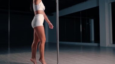 Esnek kız, direkte jimnastik yapıyor. Seksi kadın seksi vücut dansı yapıyor. Direk dansı yapıyor.