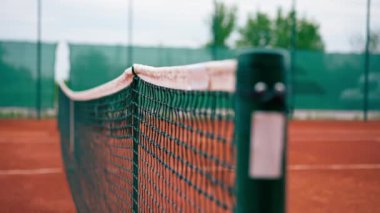 Açık hava tenis kortlarında spor ekipmanlarını eğiten bir ağ.