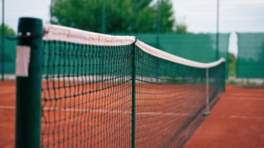 Açık hava tenis kortlarında spor ekipmanlarını eğiten bir ağ.