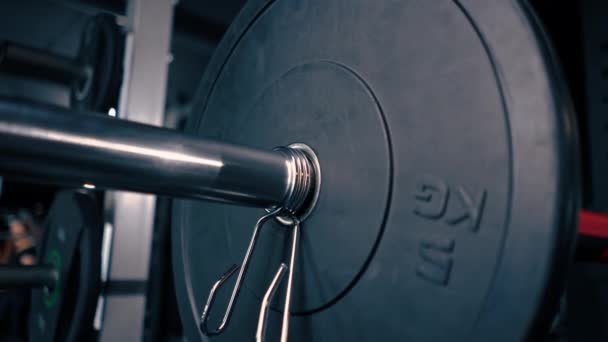 特写运动员教练给健身房的杠铃增加了重量 增加了健美运动员的身体负荷 — 图库视频影像