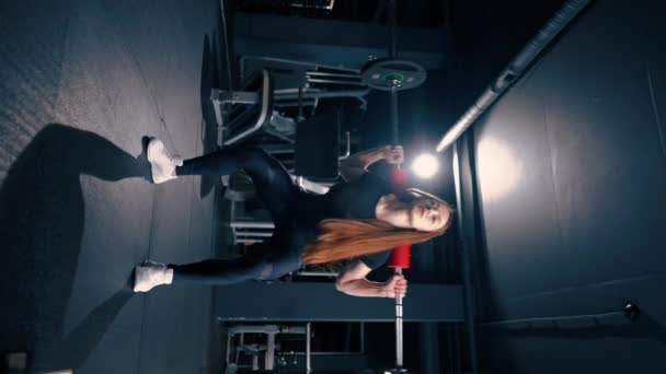 在体操训练肌肉组中 一名身体集中的女子用杠铃进行沉重的肩压运动的垂直视频肖像 — 图库视频影像