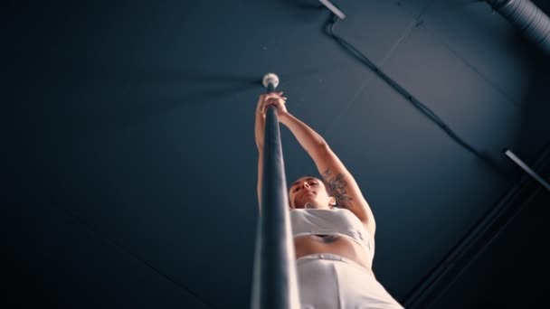 柔韧的女孩在杆子上做体操以伸展身体 漂亮性感的女人展示性感的身体撑杆舞运动 — 图库视频影像