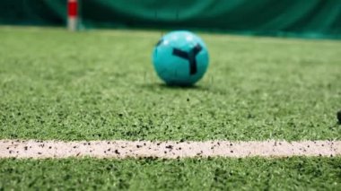 Kauçuk desenli bir futbol topunun üzerinde koşan bir elin yakın çekimi.