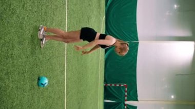 Dikey video kız futbolcu acemi futbolcu futbol sahası hobisinde topa vurmayı öğreniyor.