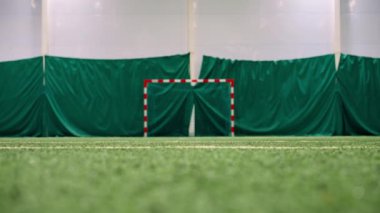 Futbol sahası manzarası bir sporcu bir futbolcu kalecinin kalesinin arka planındaki kameradan geçiyor.