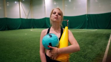 Futbol oynamayı seven genç bir kızın portresi antrenmandan sonra spor malzemelerini elinde tutuyor.