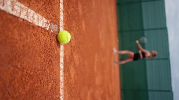 Vertikal Video Närbild Tennisboll Som Ligger Planen Bakgrunden Spelaren Tränar — Stockvideo