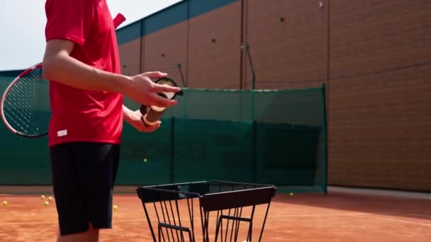 网球运动员或教练在赛后将网球从管子中倒入篮筐中 — 图库视频影像