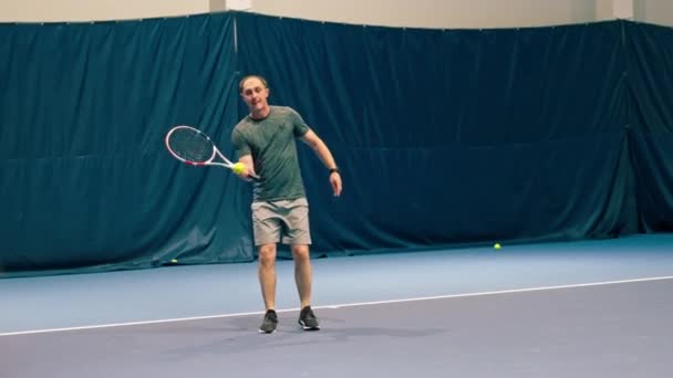 Ένας Άντρας Ένα Κλειστό Γήπεδο Τένις Ρακέτα Εκτρέπει Χτυπήματα Του — Αρχείο Βίντεο