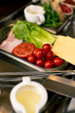 Salata malzemelerinin yakın plan çekimi profesyonel bir mutfakta, İtalyan restoranının domates salatasında salata sosu ve salata sosu.