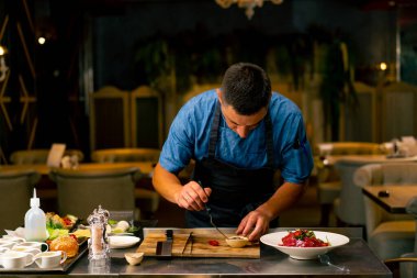 Bir İtalyan restoranının şefi profesyonel mutfakta hazırladığı yemeği süslüyor.