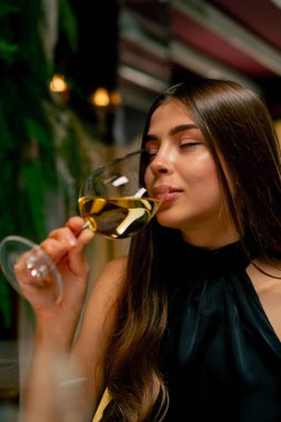 İtalyan restoranındaki bir randevuda pahalı bir şarap içen genç ve tatlı bir kızın yakın çekimi.